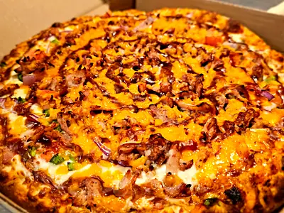 A BBQ chicken pizza with cheddar and red onion